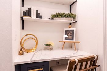 A white desk with a gold frame and a small plant on it.